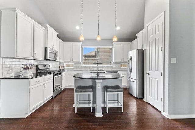 1401 Clearwing Cir, Georgetown, TX 78626 - kitchen featuring appliances with stainless steel finishes, dark countertops, a center island, tasteful backsplash, and recessed lighting