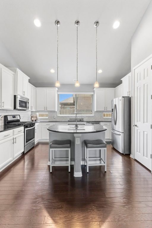 1401 Clearwing Cir, Georgetown, TX 78626 - kitchen with stainless steel appliances, tasteful backsplash, a breakfast bar area, a center island, and white cabinetry