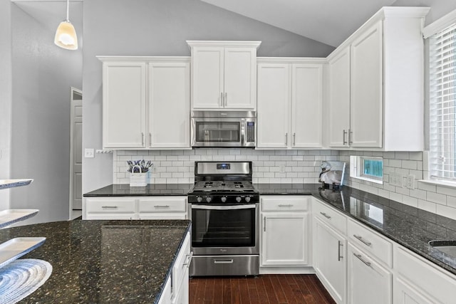 1401 Clearwing Cir, Georgetown, TX 78626 - kitchen featuring appliances with stainless steel finishes, lofted ceiling, white cabinetry, dark wood-style flooring, and backsplash