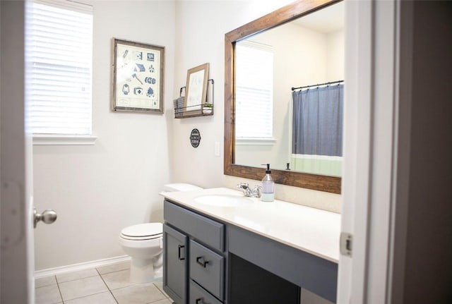 full bath featuring a wealth of natural light, toilet, tile patterned flooring, and vanity