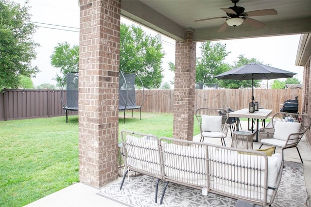 view of patio featuring a fenced backyard, ceiling fan, outdoor dining area, and a trampoline