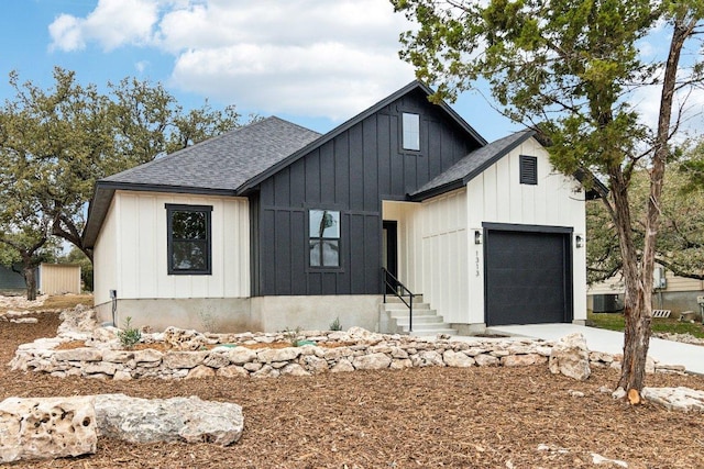 modern farmhouse featuring a shingled roof, a garage, cooling unit, driveway, and board and batten siding