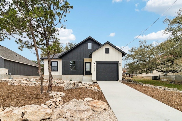 modern farmhouse style home featuring board and batten siding, central air condition unit, driveway, and an attached garage