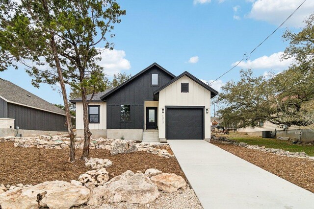 1313 Green Meadow Ln, Spring Branch, TX 78070 - modern farmhouse featuring concrete driveway, an attached garage, and board and batten siding