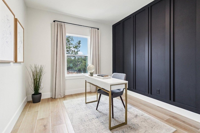 office space with baseboards and light wood finished floors