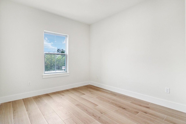 unfurnished room with light wood-style flooring and baseboards