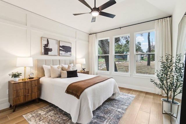 bedroom with baseboards, light wood-type flooring, and a ceiling fan