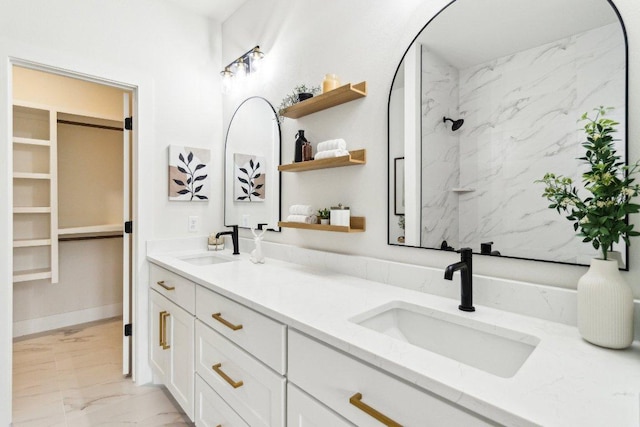 full bathroom with marble finish floor, a sink, and double vanity