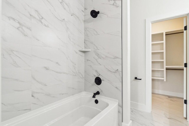 full bath featuring marble finish floor, a walk in closet, baseboards, and  shower combination