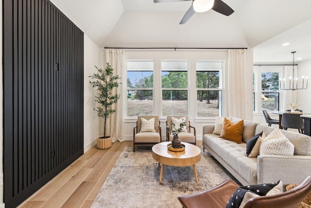 living area featuring recessed lighting, wood finished floors, ceiling fan with notable chandelier, and lofted ceiling