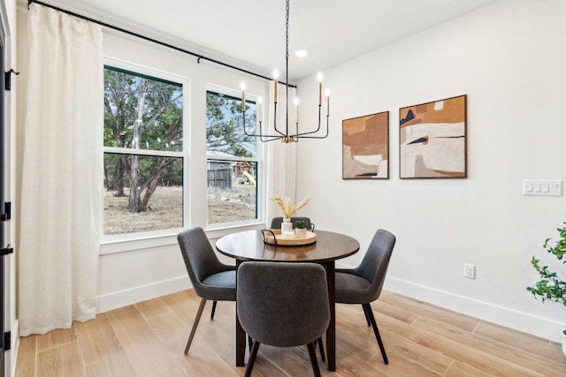 dining area with an inviting chandelier, light wood-type flooring, recessed lighting, and baseboards