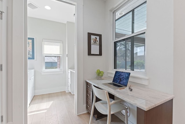 home office with visible vents, baseboards, washer / clothes dryer, and light wood-type flooring