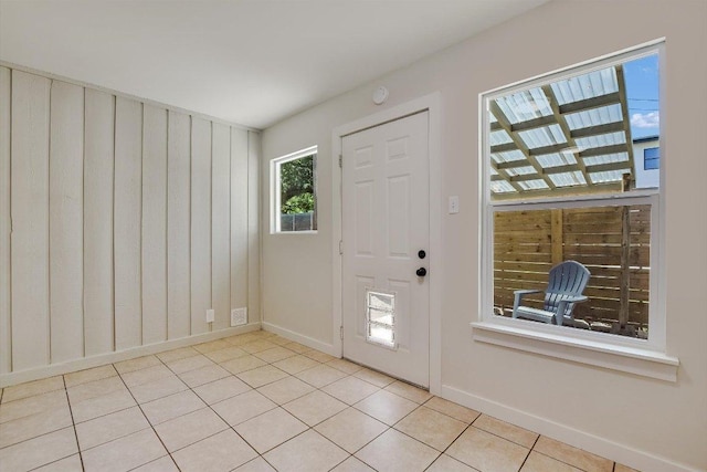 entryway with baseboards and light tile patterned floors