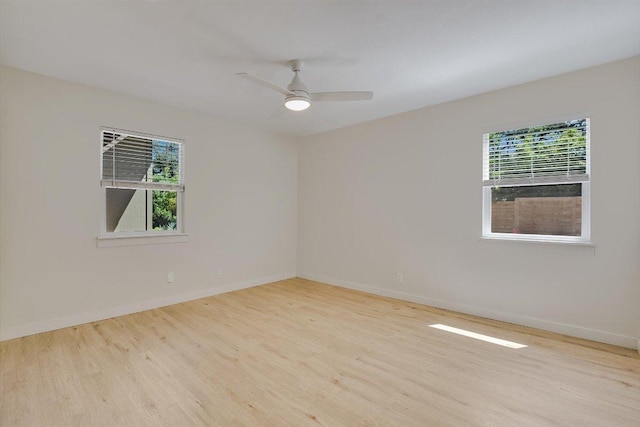empty room with ceiling fan, baseboards, plenty of natural light, and wood finished floors