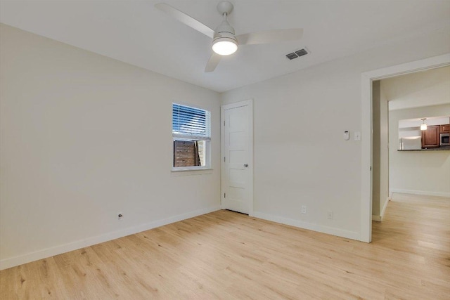 unfurnished room with light wood-style floors, baseboards, ceiling fan, and visible vents