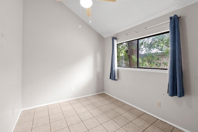 empty room featuring baseboards, light tile patterned floors, ceiling fan, and vaulted ceiling