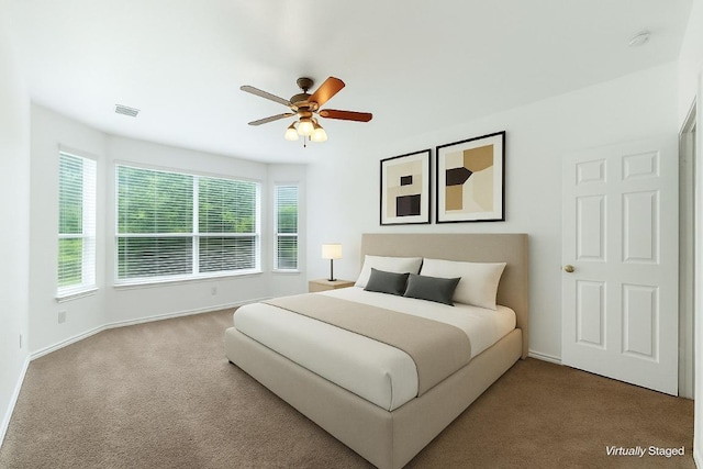 bedroom featuring baseboards, visible vents, ceiling fan, and carpet