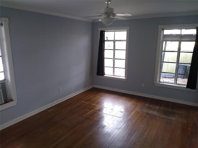 empty room featuring a ceiling fan, ornamental molding, dark wood finished floors, and baseboards