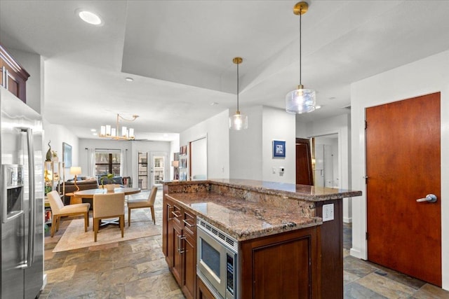1812 W Ave Unit 306, Austin, TX 78701 - kitchen with stainless steel appliances, stone tile flooring, decorative light fixtures, dark stone counters, and recessed lighting