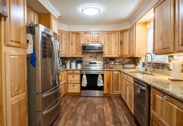 kitchen with light brown cabinets, a textured ceiling, appliances with stainless steel finishes, and a sink