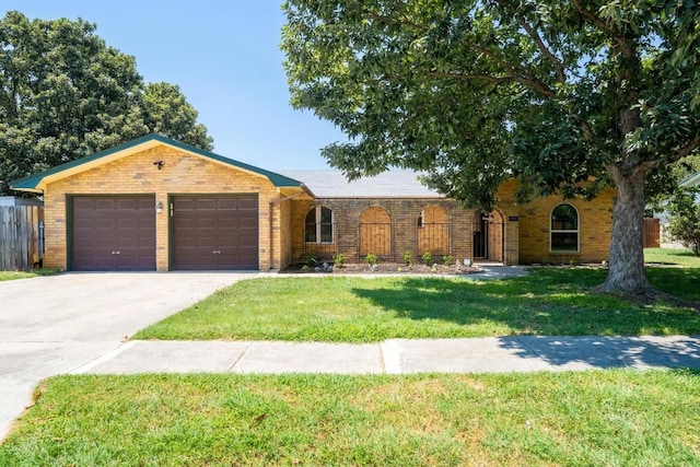 ranch-style home featuring a front yard, an attached garage, and brick siding