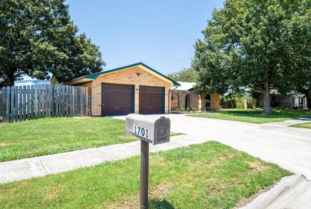ranch-style house featuring a front lawn, brick siding, and fence