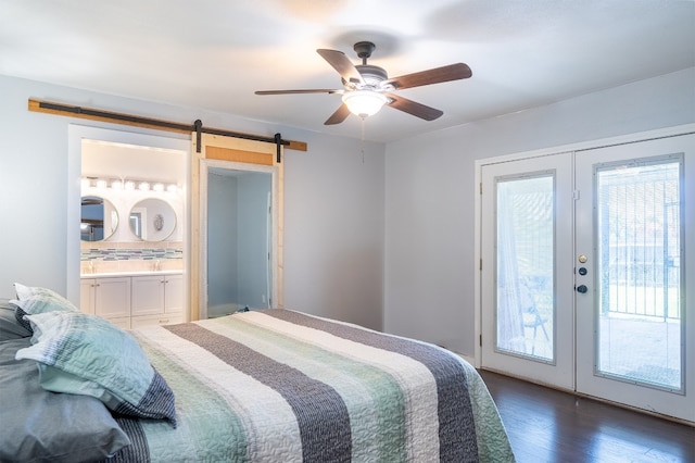 bedroom featuring dark wood-style flooring, french doors, access to exterior, and a barn door