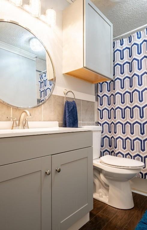 bathroom featuring tasteful backsplash, wood finished floors, tile walls, toilet, and vanity