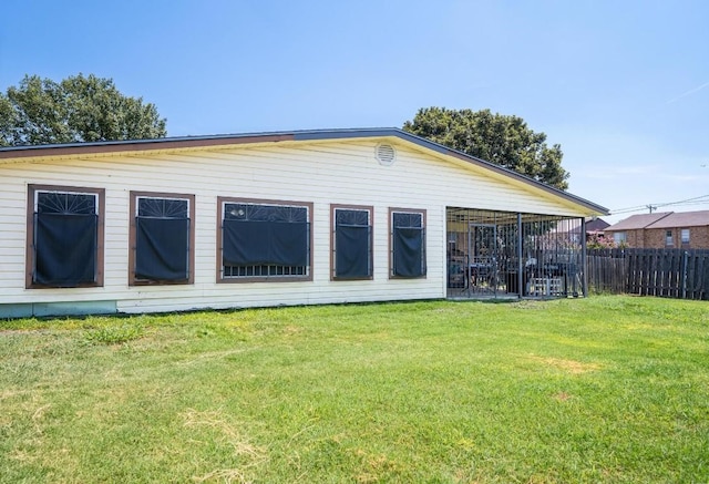 back of property with fence and a lawn