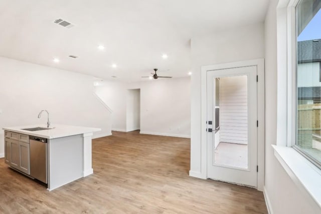 kitchen featuring light wood-style flooring, a sink, visible vents, dishwasher, and a ceiling fan