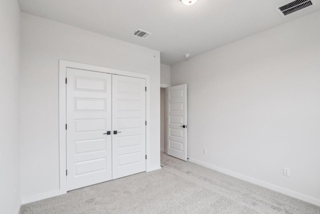 unfurnished bedroom featuring visible vents, baseboards, carpet flooring, and a closet