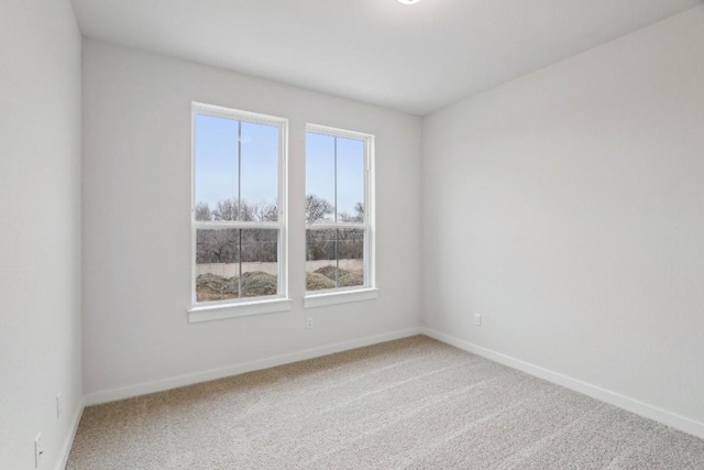 carpeted empty room with baseboards
