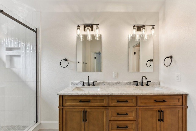 bathroom with a stall shower, double vanity, and a sink