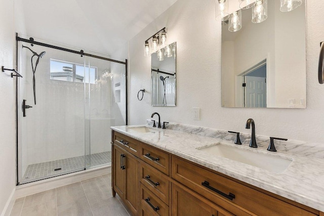 bathroom featuring a stall shower, double vanity, and a sink