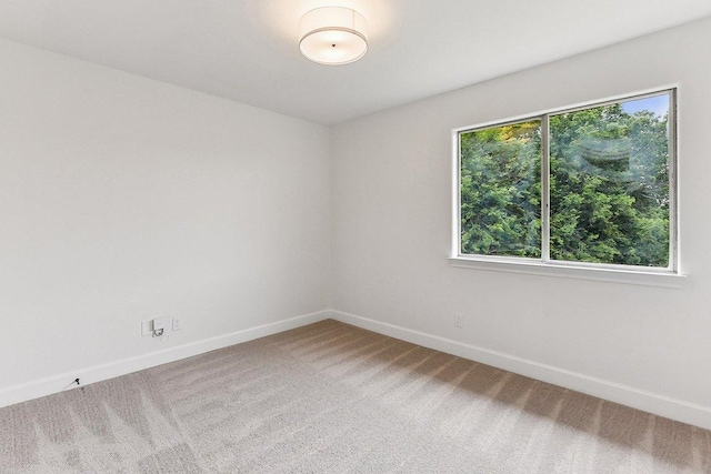 empty room with baseboards and carpet flooring