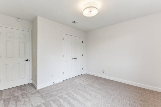 unfurnished bedroom featuring baseboards, visible vents, a closet, and carpet flooring