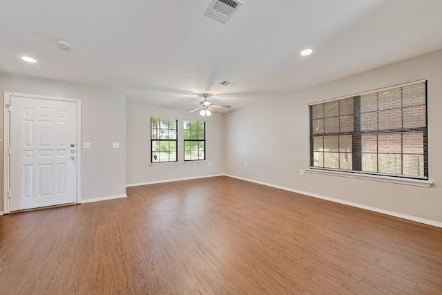interior space featuring visible vents, ceiling fan, wood finished floors, and baseboards