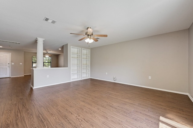 unfurnished living room with ceiling fan, visible vents, baseboards, dark wood finished floors, and ornate columns