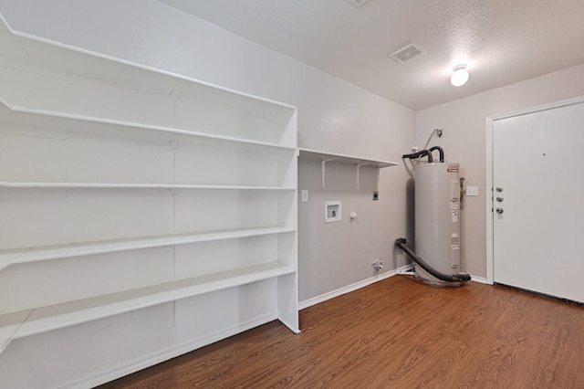 laundry room featuring washer hookup, gas dryer hookup, water heater, wood finished floors, and laundry area