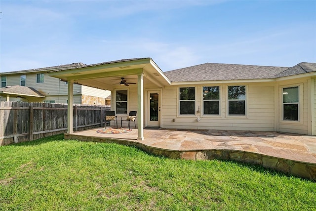 rear view of property featuring a fenced backyard, a yard, roof with shingles, a patio area, and a ceiling fan
