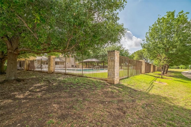view of yard with a fenced in pool and fence