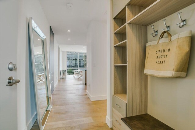 mudroom featuring recessed lighting, built in features, light wood-style flooring, and baseboards