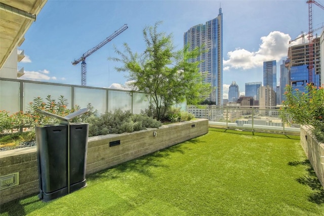 view of yard featuring a view of city and a balcony