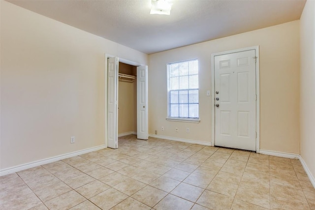 entryway with light tile patterned floors and baseboards