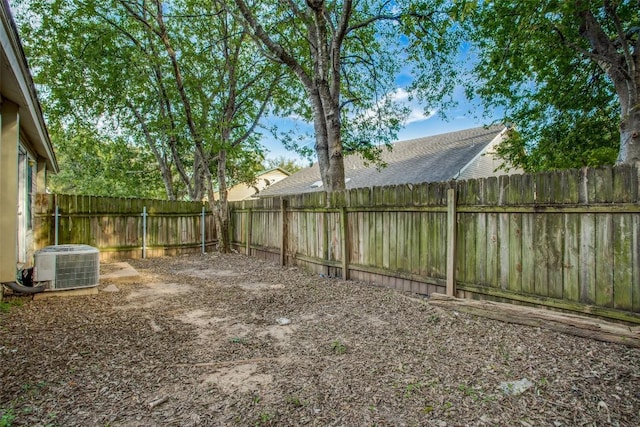 view of yard with central AC unit and a fenced backyard