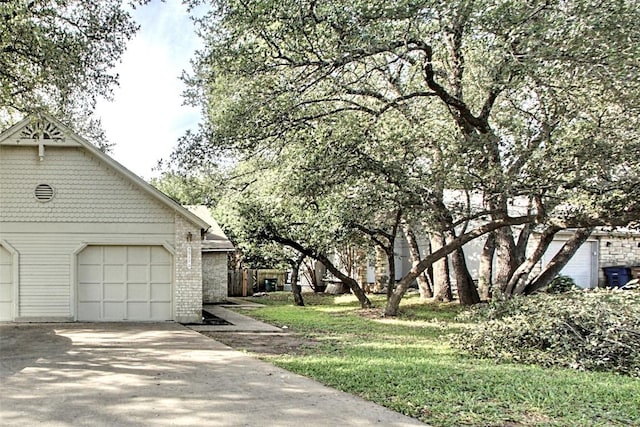 view of side of property featuring concrete driveway, brick siding, and a garage