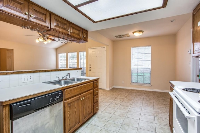 kitchen featuring light tile patterned floors, brown cabinets, dishwasher, a sink, and visible vents