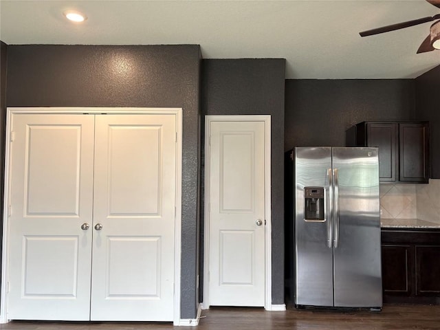 kitchen with dark brown cabinetry, backsplash, dark wood-style flooring, stainless steel refrigerator with ice dispenser, and a ceiling fan