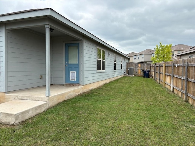 view of yard with central air condition unit and a fenced backyard