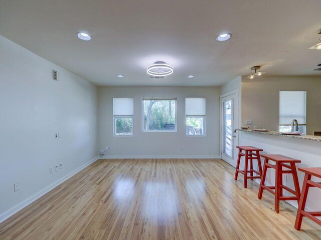 interior space with light wood-type flooring, recessed lighting, and baseboards